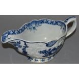 AN 18TH CENTURY BOW SAUCEBOAT, painted in blue, with rose sprays in moulded floral panels, the