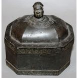 AN OCTAGONAL BOX AND COVER with a handle as a head with plain sides and two bands of scrolls. 5.5ins