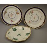 A PAIR OF 18TH CENTURY CHELSEA DERBY PLATES, painted with flowers under a Smith’s blue and gilt