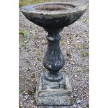 A RECONSTITUTED STONE BALUSTER SHAPE BIRD BATH with circular top on shaped square base. 2ft 5ins