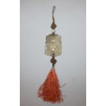 A GOOD 19TH/20TH CENTURY CHINESE PIERCED AND CARVED CELADON JADE PENDANT, with tassel attachments,