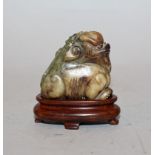 A SMALL 19TH/20TH CENTURY CHINESE JADE-LIKE CARVING OF A SEATED BUDDHISTIC LION, together with a
