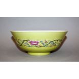 A CHINESE YELLOW-GROUND FAMILLE ROSE PORCELAIN BOWL, the sides moulded in relief with a narrow