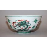 A CHINESE FAMILLE VERTE DRAGON BOWL, painted with dragons amidst flame and cloud scrolls, the base