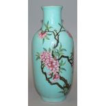 A CHINESE TURQUOISE GROUND FAMILLE ROSE PORCELAIN VASE, decorated with a blossoming branch