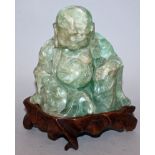 AN EARLY 20TH CENTURY CHINESE CARVED GREEN BOWENITE FIGURE OF BUDAI, together with a fitted hardwood