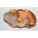 A CHINESE JADE PENDANT IN THE FORM OF A FROG, the celadon green stone with striated brown and