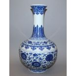 A LARGE CHINESE MING-STYLE BLUE & WHITE PORCELAIN BOTTLE VASE, the sides decorated in a ‘heaped