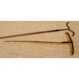 AN IRON AND A WOODEN SHEEP DIP HOOK. Both 19th century. The iron hook forms a cyma curve to double