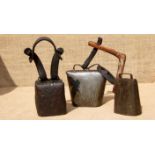 A FINE CANISTER SHEEP BELL, A LARGE CLUCKET BELL, AND A WIDE MOUTH BELL. The canister on a leather