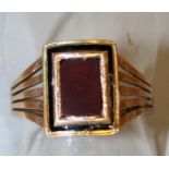 A GENTLEMAN’S GOLD AND RED STONE RING.