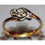 A THREE STONE DIAMOND CROSSOVER RING set in 18ct yellow gold.