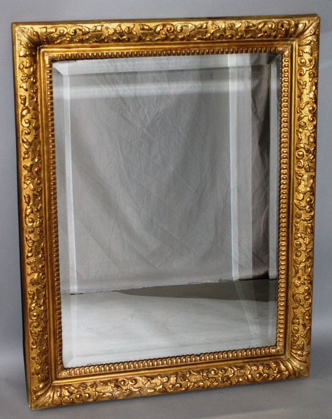 A BEVELLED MIRROR in a moulded frame. 3ft 6ins x 2ft 5ins.