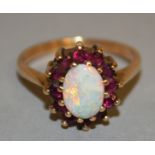 AN OPAL AND RUBY CLUSTER RING set in yellow gold.