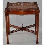 A CHIPPENDALE STYLE MAHOGANY SERPENTINE SIDED SILVER TABLE with pierced gallery, square chamfered