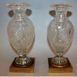 A GOOD PAIR OF 19TH CENTURY FRENCH CUT GLASS VASES on square gilt ormolu bases 10ins high.