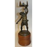 AFTER THE ANTIQUE A BRONZE OF BACCHUS holding a serpent, standing on a circular base. 11ins high.