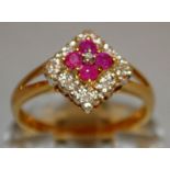 A DIAMOND AND GARNET SQUARE DRESS RING set in 9ct gold.