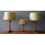 A GOOD PAIR OF BRASS COLUMN LAMPS AND SHADES and a matching smaller lamp (3).