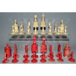 A SET OF STAINED RED AND WHITE IVORY CHESS MEN.