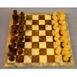 AN ONYX CHESSBOARD AND SET.