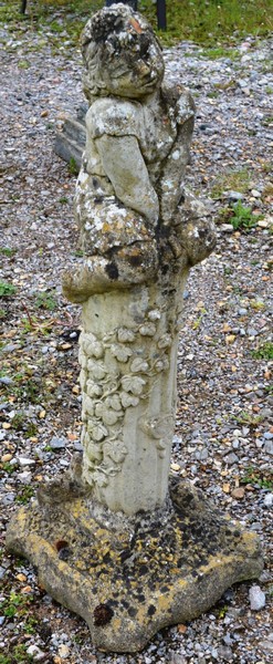 A RECONSTITUTED STONE GARDEN ORNAMENT modelled as a girl seated on a column 2ft 9ins high.