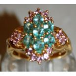 A GREEN AND PINK STONE CLUSTER RING set in 9ct gold.