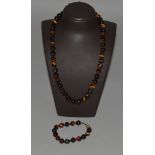 A TIGERS EYE NECKLACE of forty-five beads and a BRACELET of fifteen beads.