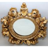 A GOOD 19TH CENTURY ITALIAN CARVED AND GILDED CIRCULAR MIRROR, the pierced frame with flowers and