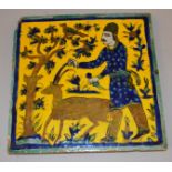 A PERSIAN SQUARE TILE “THE SACRIFICE”, a man holding a knife with a goat 9ins square.