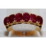 A VERY GOOD SIX STONE RUBY RING set in yellow gold.