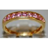 A GOOD NINE PINK STONE HALF ETERNITY RING set in 9ct gold.