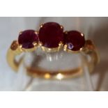 A THREE STONE RUBY RING set in 22ct yellow gold.