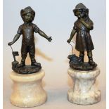 A SMALL PAIR OF BRONZES, a young boy with a toy boat and a girl with a pet rabbit, on circular