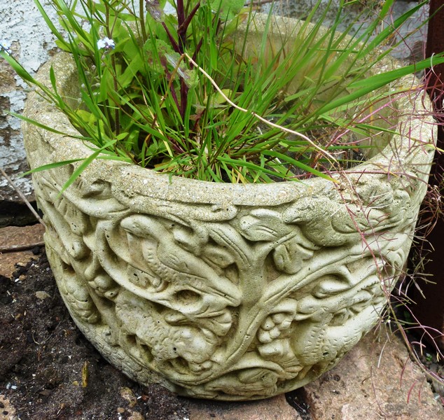 A SMALL RECONSTITUTED STONE GARDEN PLANTER with moulded decoration 8ins high.