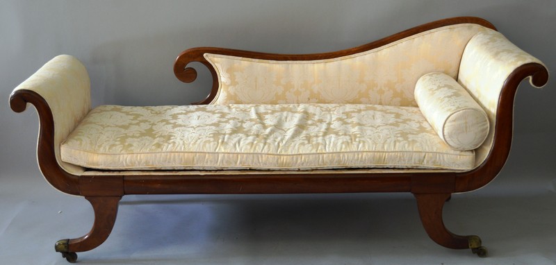 A REGENCY MAHOGANY SCROLL END SOFA with show wood frame, supported on curving legs with brass cap