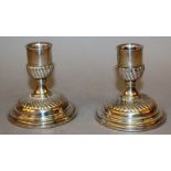 A PAIR OF SQUAT SILVER CANDLESTICKS with loaded bases. 3.5ins high.