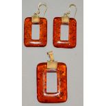 AN AMBER PENDANT AND EARRINGS.