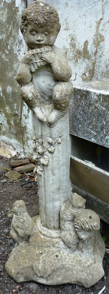 A RECONSTITUTED STONE GARDEN ORNAMENT modelled as Pan 2ft 10ins high.