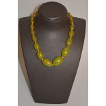 A CHINESE GREEN AMBER-TYPE NECKLACE, with graduated beads.