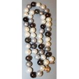 A STRING OF BLACK AND WHITE PEARLS.