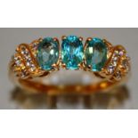 A GOOD THREE STONE TURQUOISE RING with diamond shoulders, set in 9ct gold.