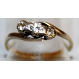 A THREE STONE DIAMOND RING in 18ct yellow gold.