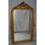 A LARGE GILTWOOD UPRIGHT MIRROR with bevelled mirrored panel and ornate frame with acanthus and
