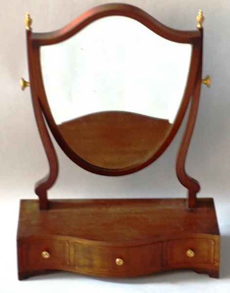 A GEORGIAN STYLE MAHOGANY SERPENTINE FRAMED TOILET MIRROR with shield shaped mirror and three