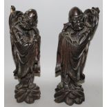 A MIRROR PAIR OF 19TH/20TH CENTURY CHINESE CARVED WOOD FIGURES OF SAGES, each standing on a wave