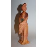 A CHINESE TANG STYLE POTTERY FIGURE OF A COURT LADY, standing and dressed in flowing robes, 9.4in