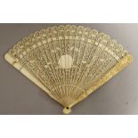 A 19TH CENTURY CHINESE CANTON IVORY FAN, with twenty thin pierced and carved inner sticks, the two