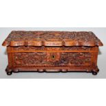 A 19TH CENTURY CHINESE CARVED SANDALWOOD CASKET & COVER, of shaped rectangular form, decorated in