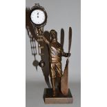 A BRONZED FLYING PILOT PENDULUM CLOCK holding a propeller on square base 11.5ins high.